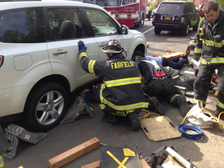 Fairfield and Bridgeport firefighters worked to raise a vehicle to pull an injured woman out from under the car.