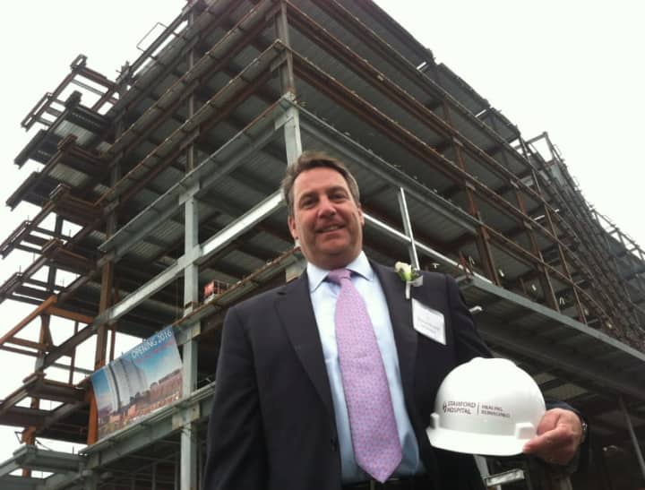 Christopher Riendeau, senior vice president of fund development, stands in front of the new Stamford Hospital. The hospital celebrated a major milestone in its construction by having a &quot;topping off&quot; event. The new hospital will be ready by mid-2016.
