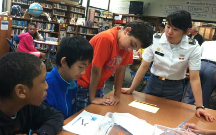 West Point Military Academy cadet Rebecca Lee helps from left: Matthew Midy, Andrew Fang and Tyler Brown during robotics event Tuesday at Cloonan Middle School to encourage students interest in engineering, math and science 