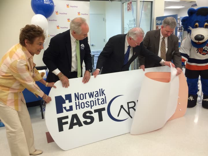 Fairfield First Selectman Michael Tetreau with Arlene Putterman, Community Relations Manager for Stop &amp; Shop; Dr. Michael Marks of Norwalk Hospital and Brad Dayton of Ahold rip off the bandaid to open the new Fast Care Clinic in Fairfield.