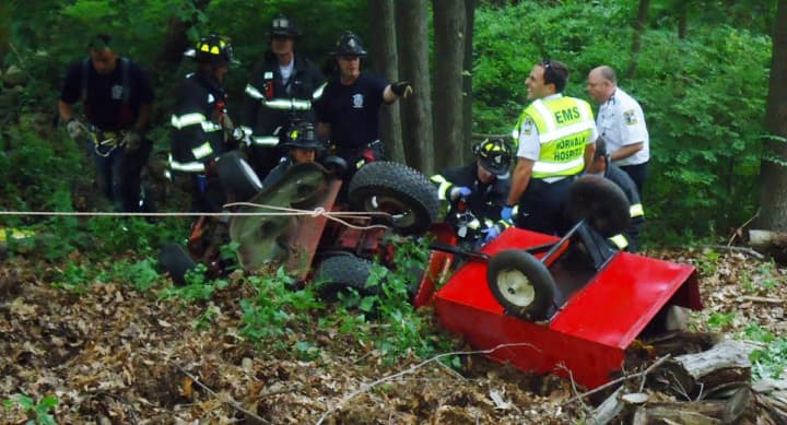 Norwalk firefighters help a man injured in a lawn tractor accident Tuesday evening. 
