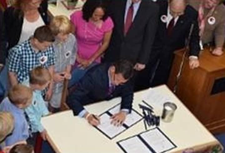 Gov. Dannel P. Malloy signs Public Acts No. 14-39 and 14-41 at Helen Street School in Hamden on Wednesday, May 28.