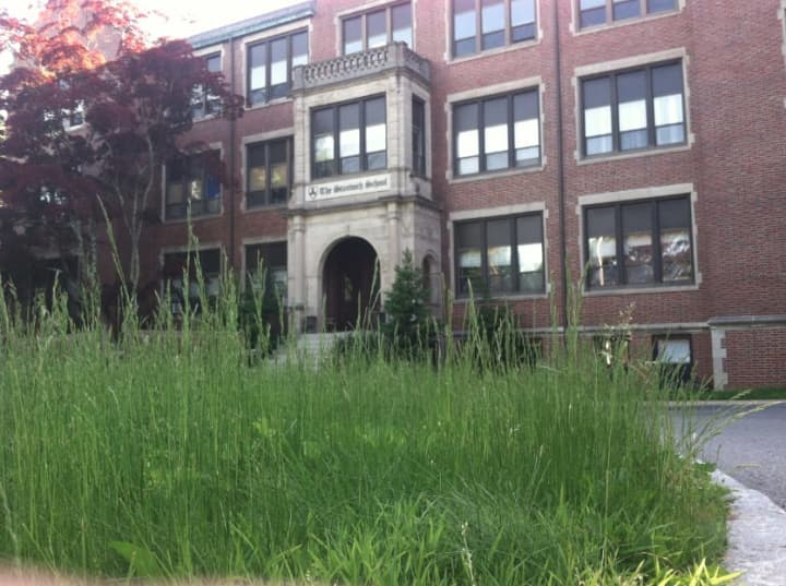Uncut grass grows tall in front of The Stanwich School at 200 Strawberry Hill Ave. on Thursday. The city has reached an agreement with the owners to buy the 10.8-acre site. Stanwich School had been leasing it but will move its students to Greenwich.