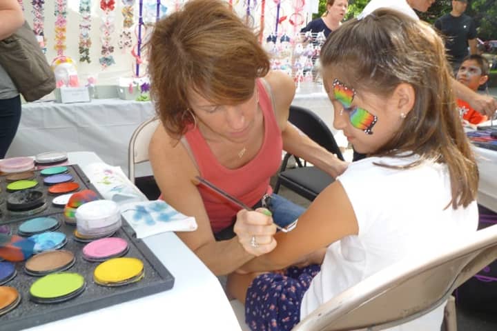 A girl gets her arm painted with an Italian flag Sunday at the 2012 Pelham Street Fair. 