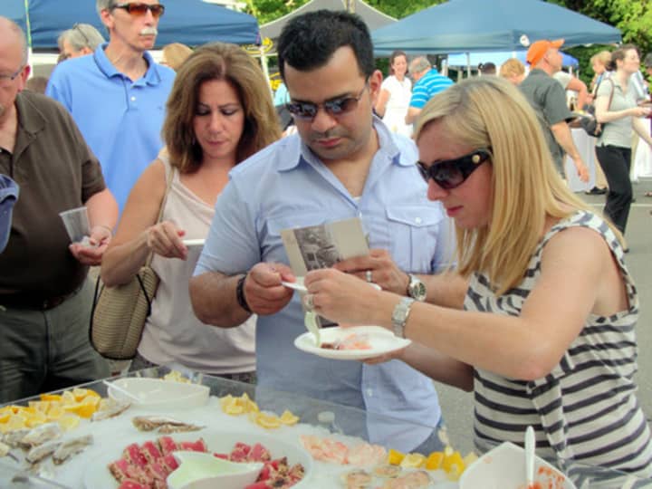 People try samples of food during a past year&#x27;s Taste of Wilton event.