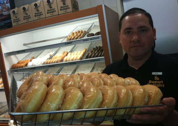 Salvador Carrera, manager of the Donut Delight location at 274 Hope St., holds up a tray of honey dip doughnuts on National Donut Day.
