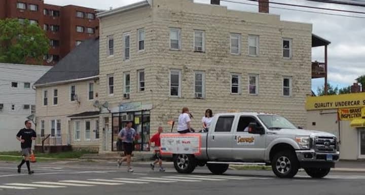 The runner with the Special Olympics torch makes the turn from Main Street onto South Street near Rogers Park in Danbury on Friday morning. 