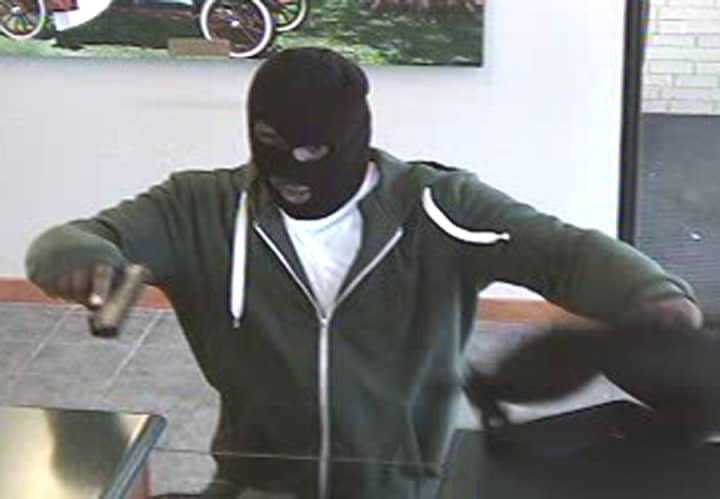 The suspect who robbed the TD Bank on the Post Road in Fairfield displays a dark-colored semi-automatic pistol, police said.