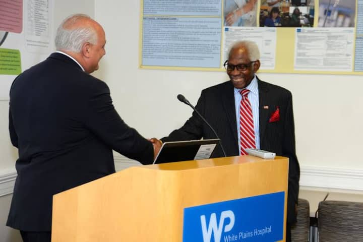 Dr. Valiere Alcena, longtime member of the White Plains Hospital medical Staff, shakes hands last week with the hospital&#x27;s Executive Vice President and Medical Director Dr. Michael Palumbo at reception. 