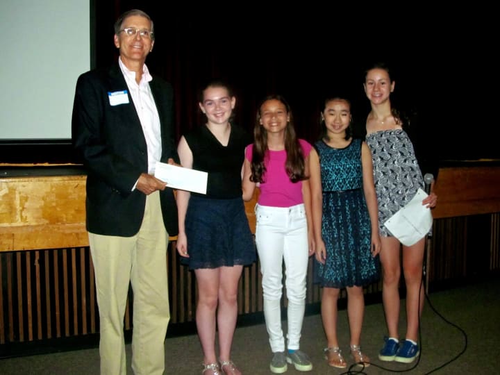 Hillary O&#x27;Neill, Ellie Arrow, Lia Chen, and Mia Fraas donate a check to Jeff Weiser from Homes with Hope