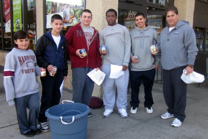 Art Troilo Jr., right, with Harrison football players who collected 350 cans of soup to be donated to a local food pantry. 