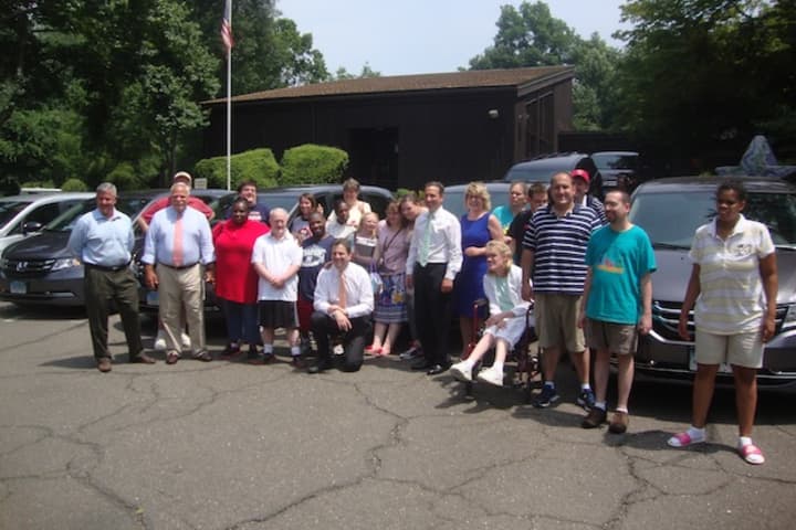 Norwalk representatives, STAR Inc. staff and STAR clients with the fleet of new vans purchased with a state grant.