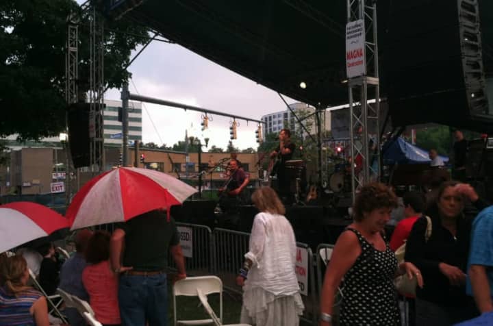 The audience scrambles for cover as rain comes down during the Bacon Brothers performance at Jazz Up July on Wednesday at Columbus Park in Stamford. The show resumed after a 15-minute break.