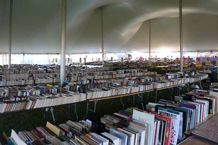 Thousands of books are stacked underneath a giant tent on Jesup Green before the Westport Library&#x27;s annual Summer Book Sale in a past year. The event begins Saturday. 