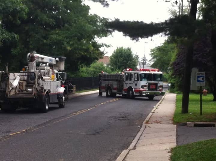 The Norwalk Fire Department blocks Ely Avenue with fire engines on Tuesday morning after a pole caught fire, causing power outages through the neighborhood. 