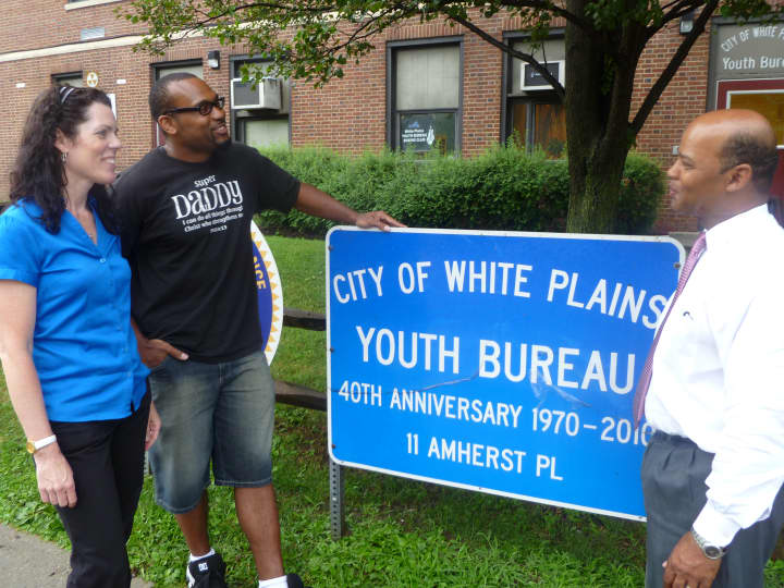Sheila Foley (left) and Frank Williams (right) welcome back Marcus Walton as he visits the White Plains Youth Bureau. 