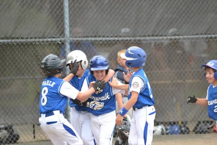 Matt Claps is congratulated by teammates after hitting a grand slam for the Norwalk Cal Ripken 9-year-old All-Stars in a game against South Meriden. 