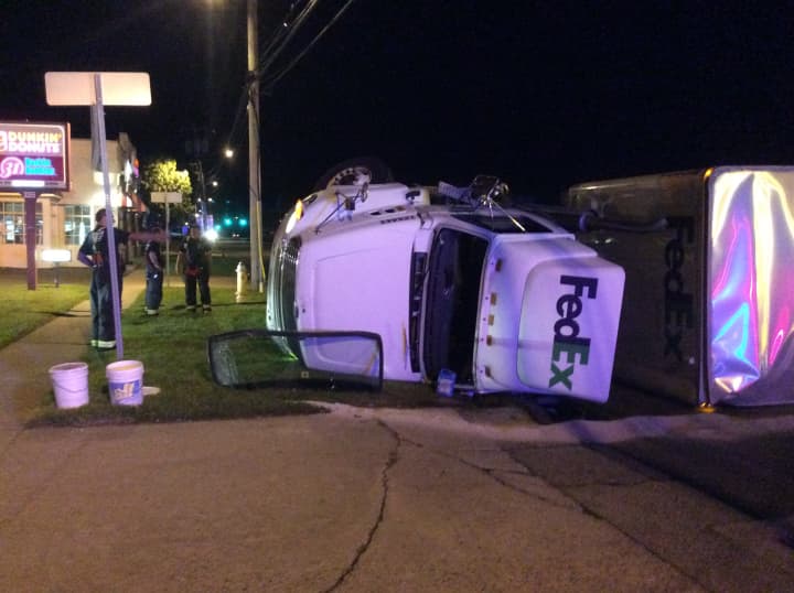 A FedEx tractor-trailer lies in the roadway on the Post Road in Fairfield early Wednesday after a rollover accident.