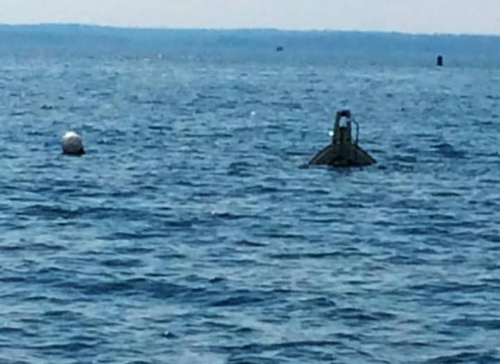 The bow of a sunken 26-foot Bayliner sticks out of the water in Long Island Sound. It sunk Saturday night west of Captain  Island but all five people were rescued by Greenwich Police.