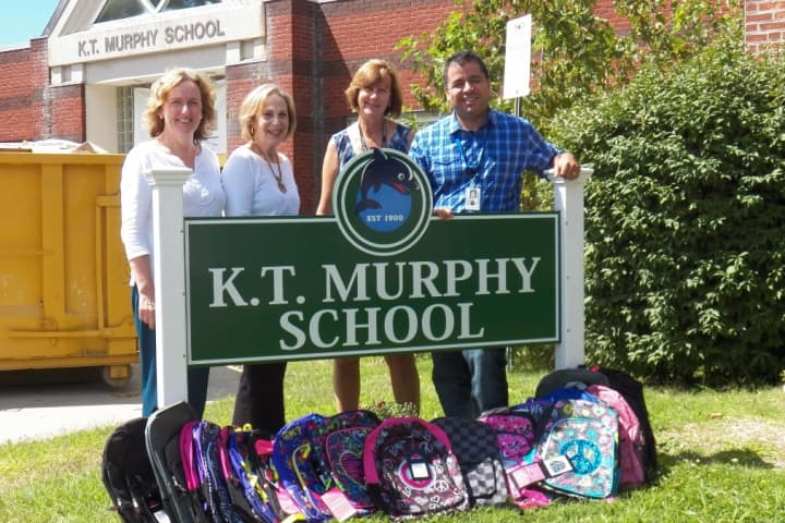 K.T. Murphy Elementary Principal, Frank Rodriguez, right, and Assistant. Principal, Beth Keenan receive backpacks from Kathy Barcello and Maddy Shapiro, who are on the Board of Directors for the Stamford Board of Realtors.

