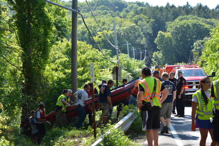 A boat is carried by responders near the Croton Falls Reservoir in Carmel.