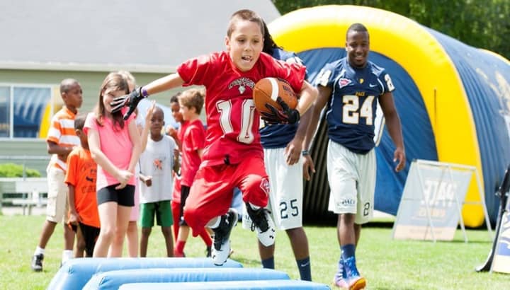 Pace University football players coordinated youth clinics for children at fan fest in Pleasantville. 