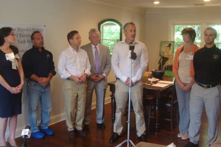 John Kydes and other Norwalk officials gather at his home to discuss the value of having a home energy efficiency assessment performed.
