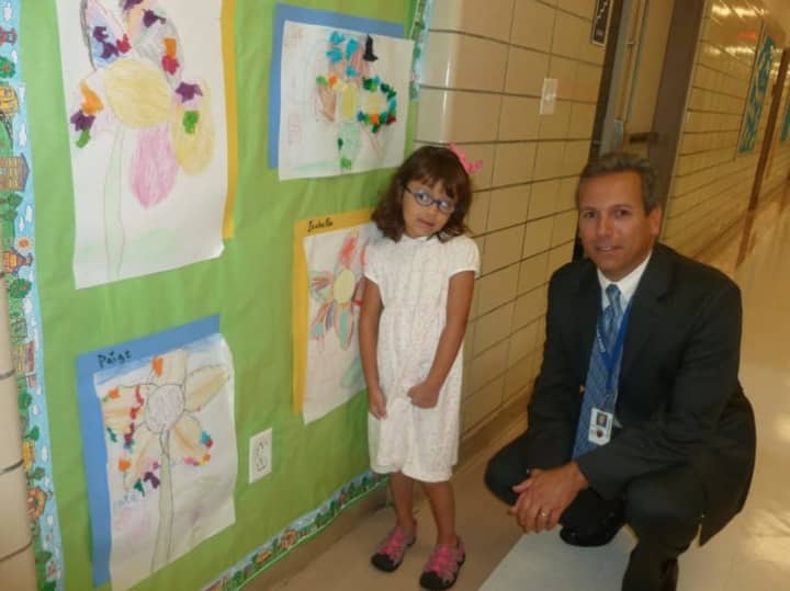 Julia A. Stark School first grade student Zoe Guaman looks at some artwork on the wall along with her principal Mark Bonasera on the first day for Stamford Public Schools on Tuesday.