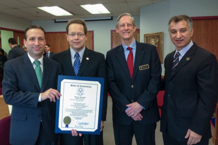 State Sen. Bob Duff (D-Norwalk), left, and State Sen. Carlo Leone (D-Stamford), right, present an official citation to David Levinson, president of Norwalk Community College, and Robert Baer, dean of students at the college.