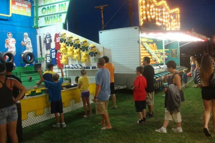 Fairgoers at the Norwalk Oyster Festival enjoy midway games. The festival reopens at 11 a.m. Sunday. 