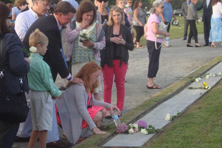 Family members place flowers on the Sept. 11 memorial in Sherwood Island State Park in Westport Wednesday night.