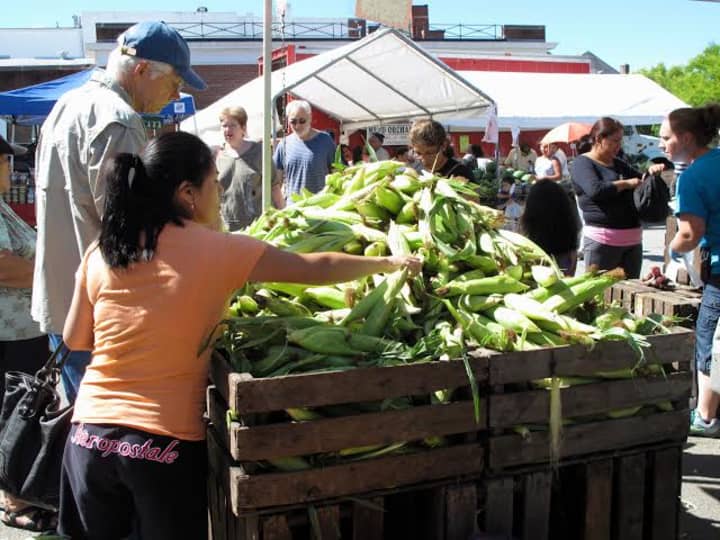 Visitors shop for corn at the Down to Earth Farmers Market. 