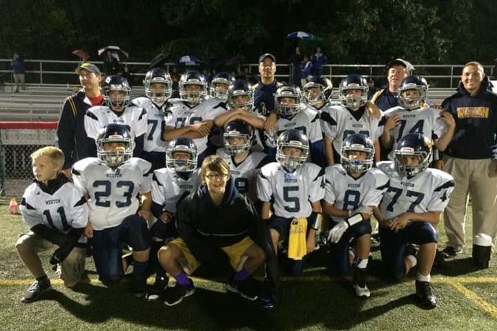 The Weston 7th grade football team celebrates its 8-6 win over New Canaan Red on Saturday.
