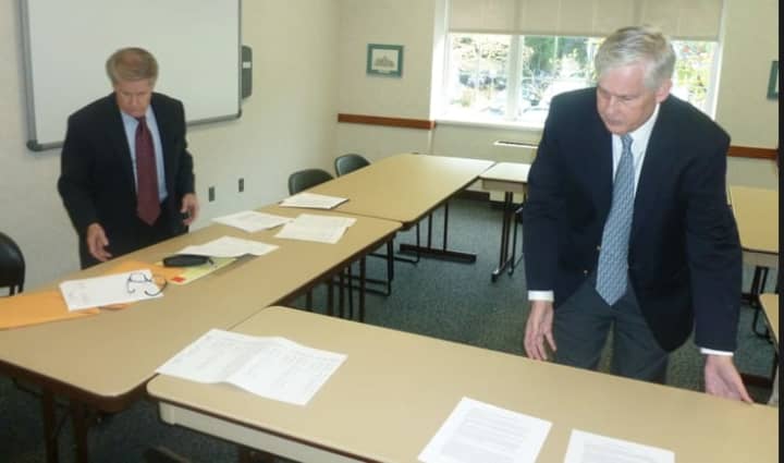 Two Greenwich Democrats, Randy Huffman, left, and Sean Goldrick, right, put out papers before holding a press conference to explain their proposals for an alternate town budget. 