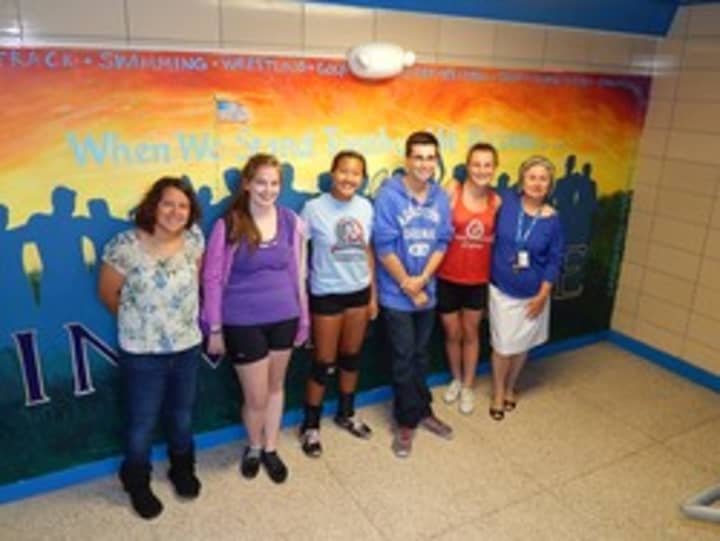 Jan Aiello and student artists with their Invincible mural.