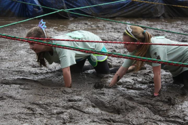 Girls make their way through a muddy section of the Mud Run hosted by the Boys &amp; Girls Club of Greenwich last year. 