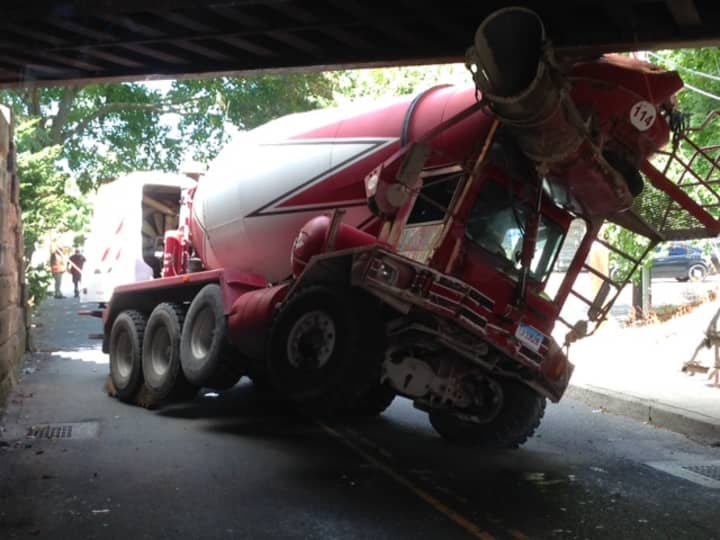 A cement truck hit and became wedged under the railroad bridge on Mill Plain Road in Fairfield on Monday. 