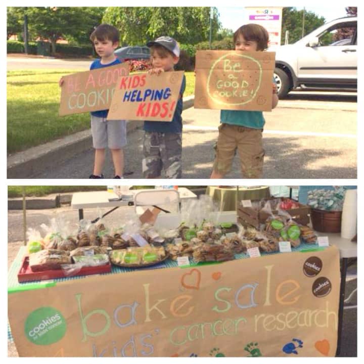 Kids push baked good at a cookie sale to benefit Cookies for Kids&#x27; Cancer held in Danbury during the summer. 