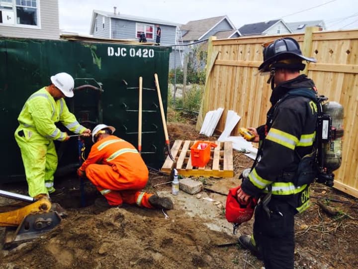 Southern Connecticut Gas leadman Manny Almedia and machine operator Albert Cancel respond to the scene with Fairfield firefighter Jordan Charney.
