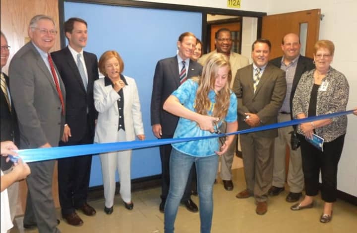 Cloonan Middle School student council president Maura Johnstone cuts the ribbon during the official opening of the Family Centers new clinic in the Stamford school.