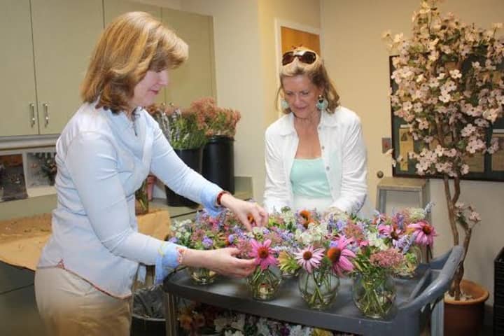 Mary Tanzi and Carroll Yanicelli, flower volunteers, prepare cut flowers for display in 
Waveny Care Centers Main Dining room.
