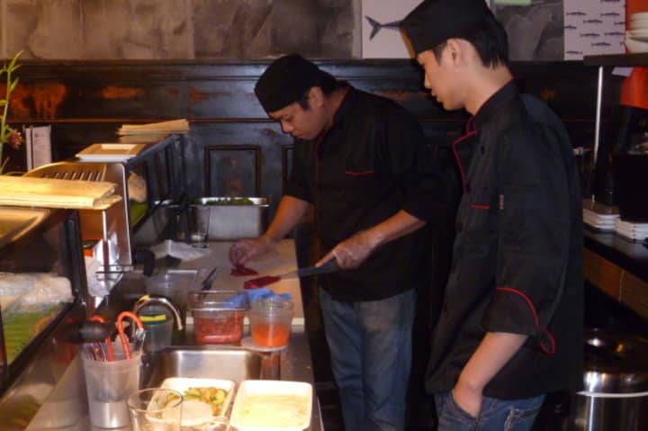 Chefs in the sushi bar at Oishi, a new restaurant on Washington Street in South Norwalk, work on a dish.