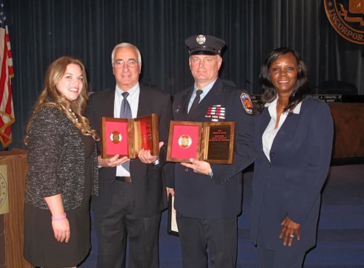 Liberty Mutual representatives Sales Representative Kathryn Ilardi, le and Senior Branch Manager Genet Hardesty presented the Liberty Mutual Fire Mark Award to Chief Lou DiMeglio for the New Rochelle Fire Department and Firefighter Daniel Thompson.