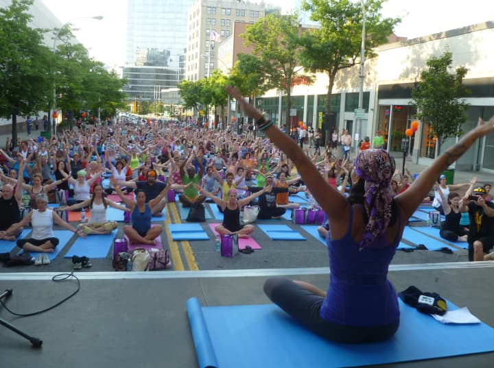 Gwen Lawrence of White Plains leads more than 500 people in an outdoor mega yoga class Wednesday evening on Court Street in White Plains.