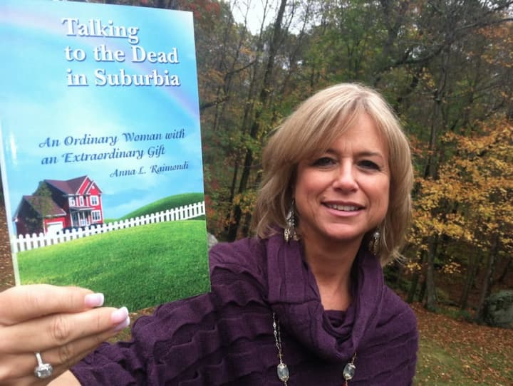 Wilton resident Anna Raimondi uses her spiritual psychic powers to help others. She&#x27;s holding one of the two books she has written.