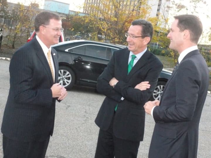 Daniel McCarthy, president and chief operating officer of Stamford-based Frontier Communications, speaks with Gov. Dannel P. Malloy, center, and U.S. Rep. Jim Himes, before a Monday evening ceremony celebrating the company&#x27;s expansion into the state.