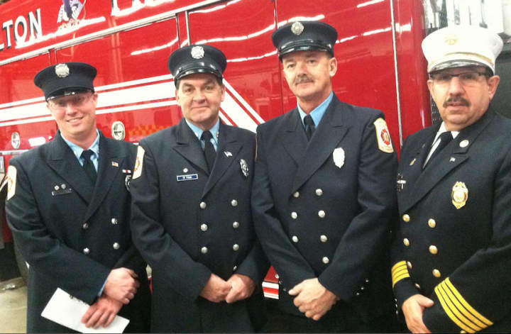 Wilton Fire Department firefighters from left, Brian Elliott, Kevin Plank, Ralph Nathanson and Deputy Chief AMark Amatrudo, Ralph Nathanson, stand in front of Engine 4, the new addition to the department&#x27;s fleet, following a ceremony Wednesday.
