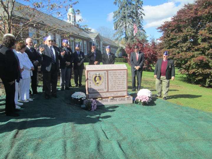 Veterans gather around a new memorial honoring Purple Heart recipients. 