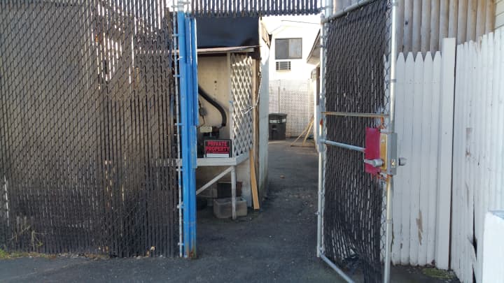 A look from outside the entrance to the back alleyway of the Seagrape Cafe, located in the back left corner of its parking lot. A sign shown above marks it as &quot;private property.&quot;