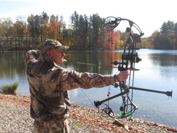 Dean Renzi displays his bow hunting form near Silver Lake in North Castle. 